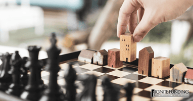 man working on laptop computer with icons representing real estate investment loans